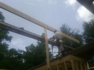 Carpenter setting a ridge beam over a new addition frame — Ice Dam Removal by Roofing Brothers in La Jose