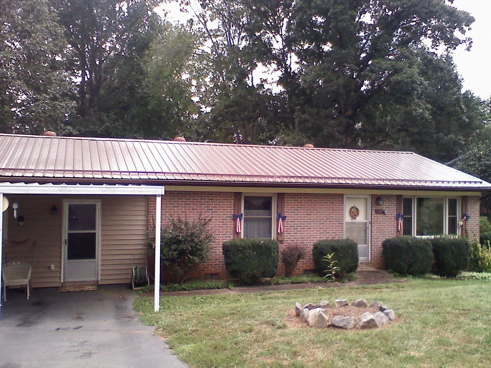 Bronze metal roof and carport on a brick ranch home in La Jose